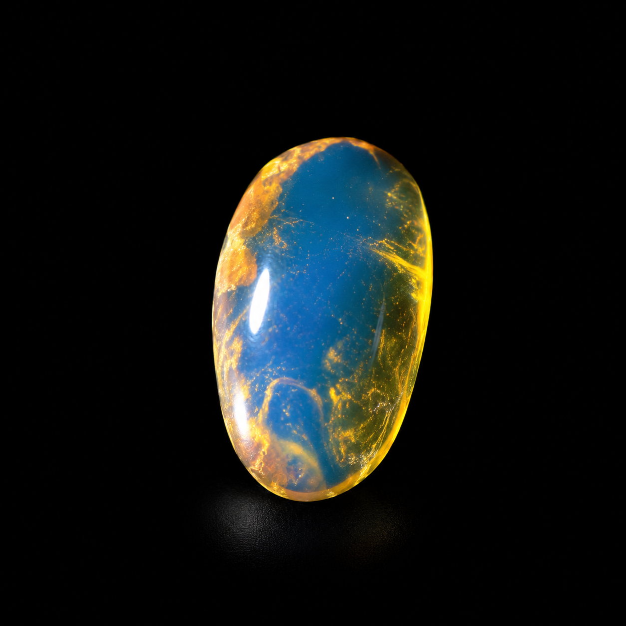Polished blue amber cabochon with honey yellow edge